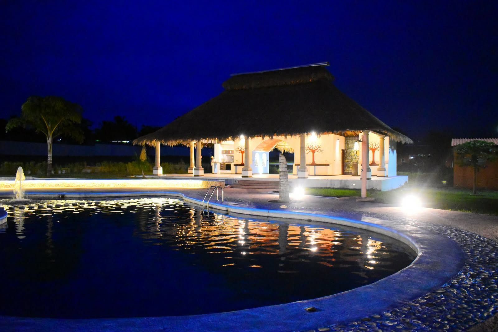 Palapa reflejada en la alberca al atardecer