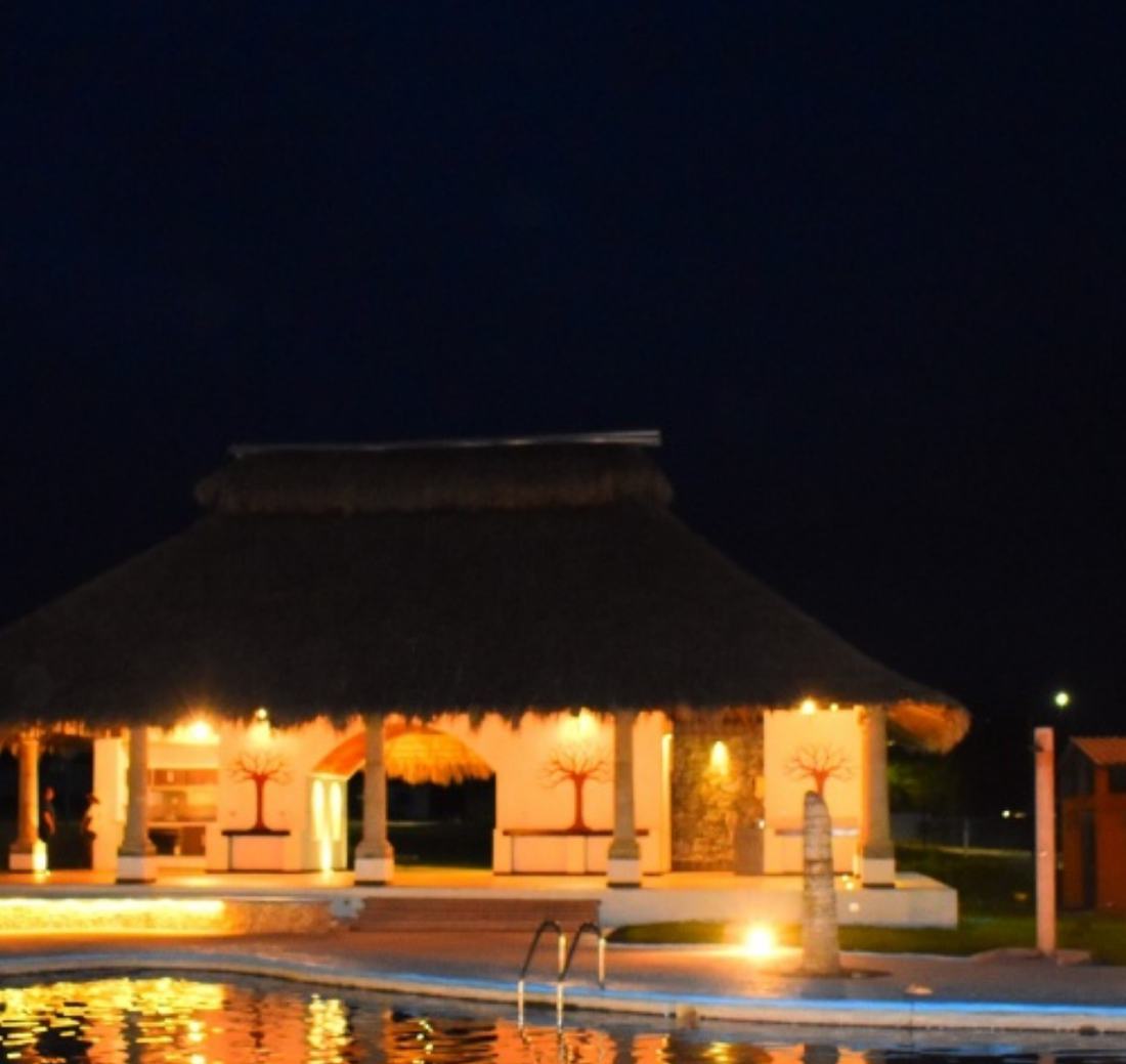 Palapa y alberca iluminadas de noche