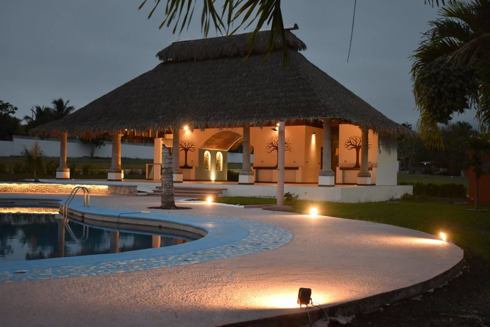 Palapa y alberca al atardecer