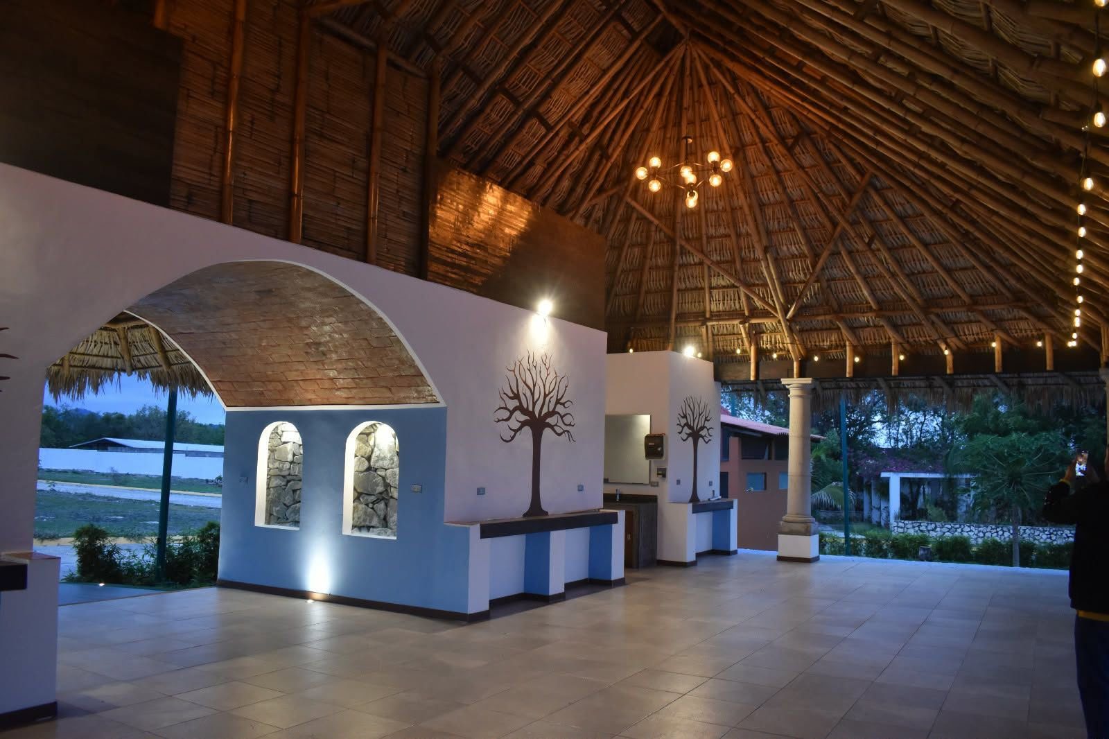 Interior de la palapa con detalles decorativos, de noche